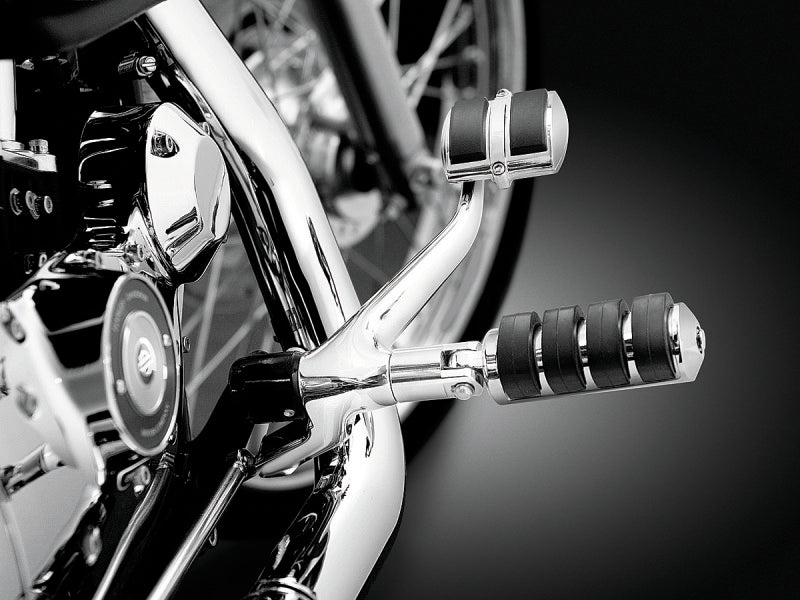 Close-up of a motorcycle's foot pegs and chrome details on a dark background
