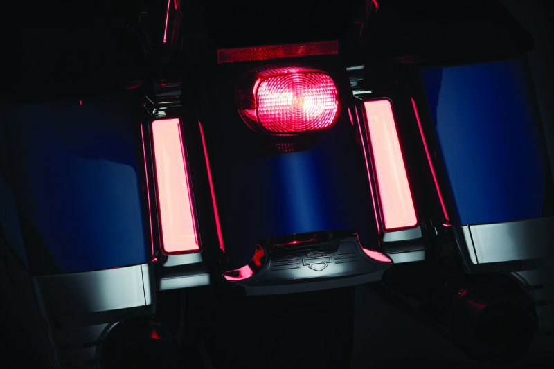Close-up of a red motorcycle tail light on a dark background