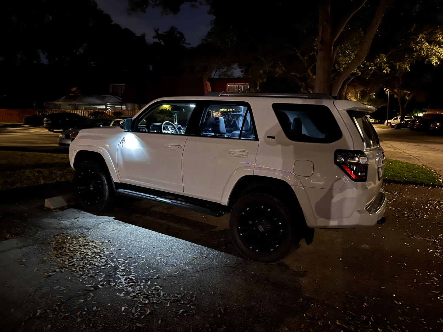 White SUV parked on a dark street at night