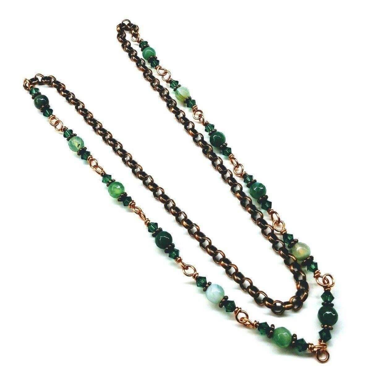 Necklace with green beads and bronze chain on a white background