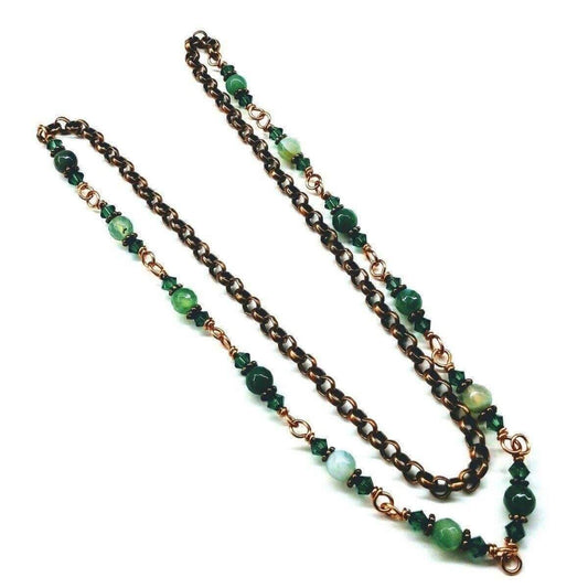 Necklace with green beads and bronze chain on a white background