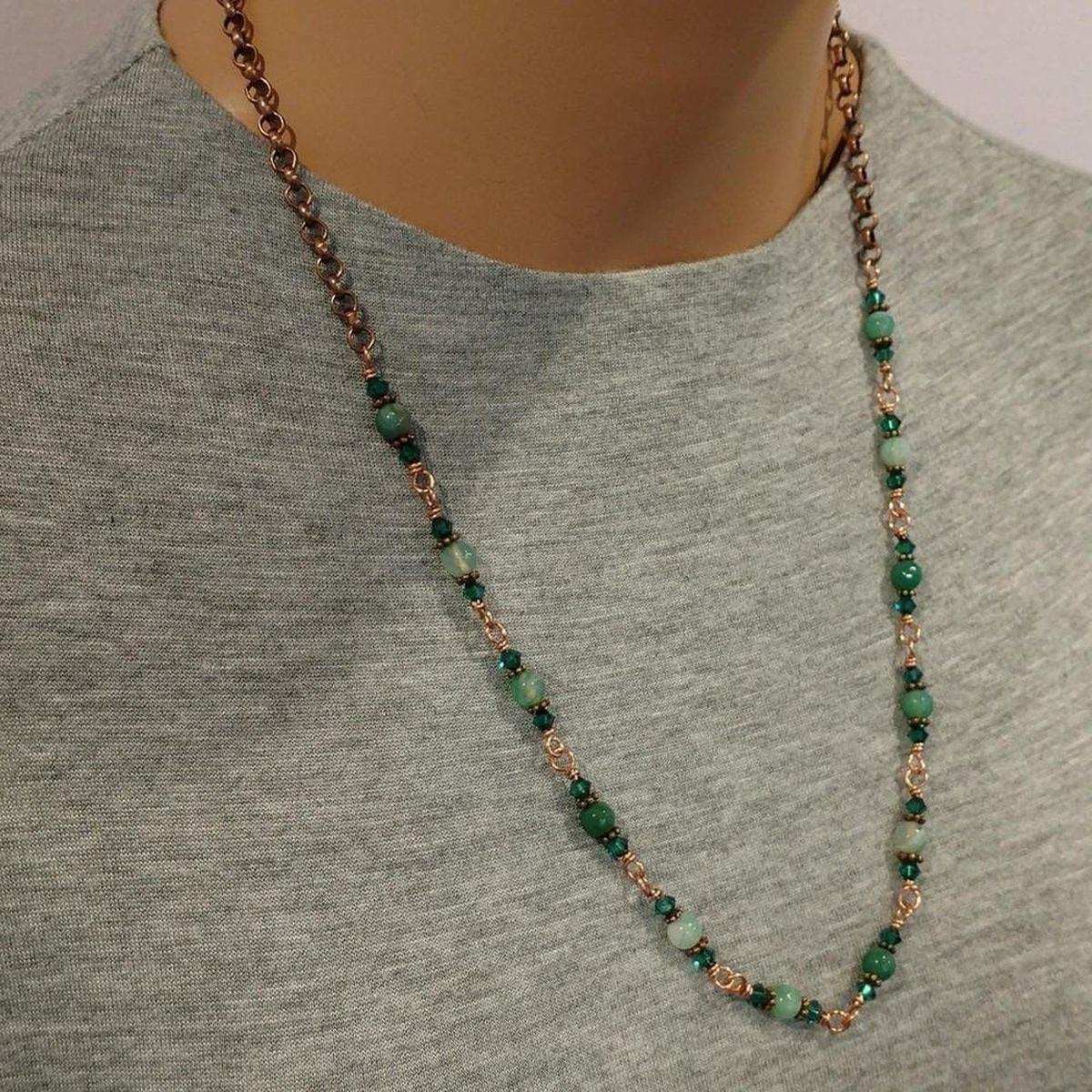 Necklace with green beads and rose gold chain on a mannequin wearing a gray shirt.