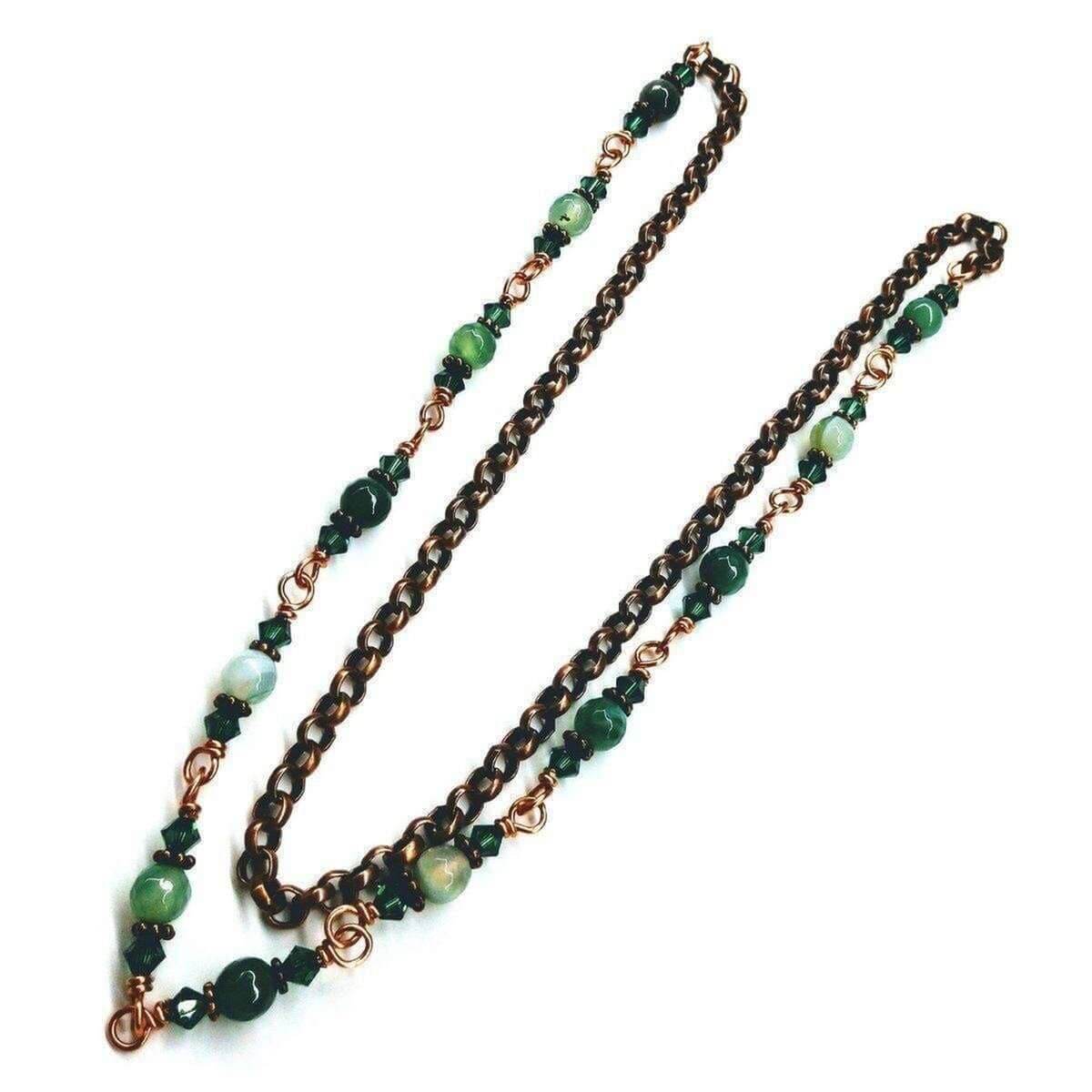 Necklace with green beads and bronze chain on a white background