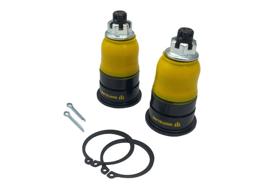 Two yellow shock absorbers with black caps and mounting hardware on a white background