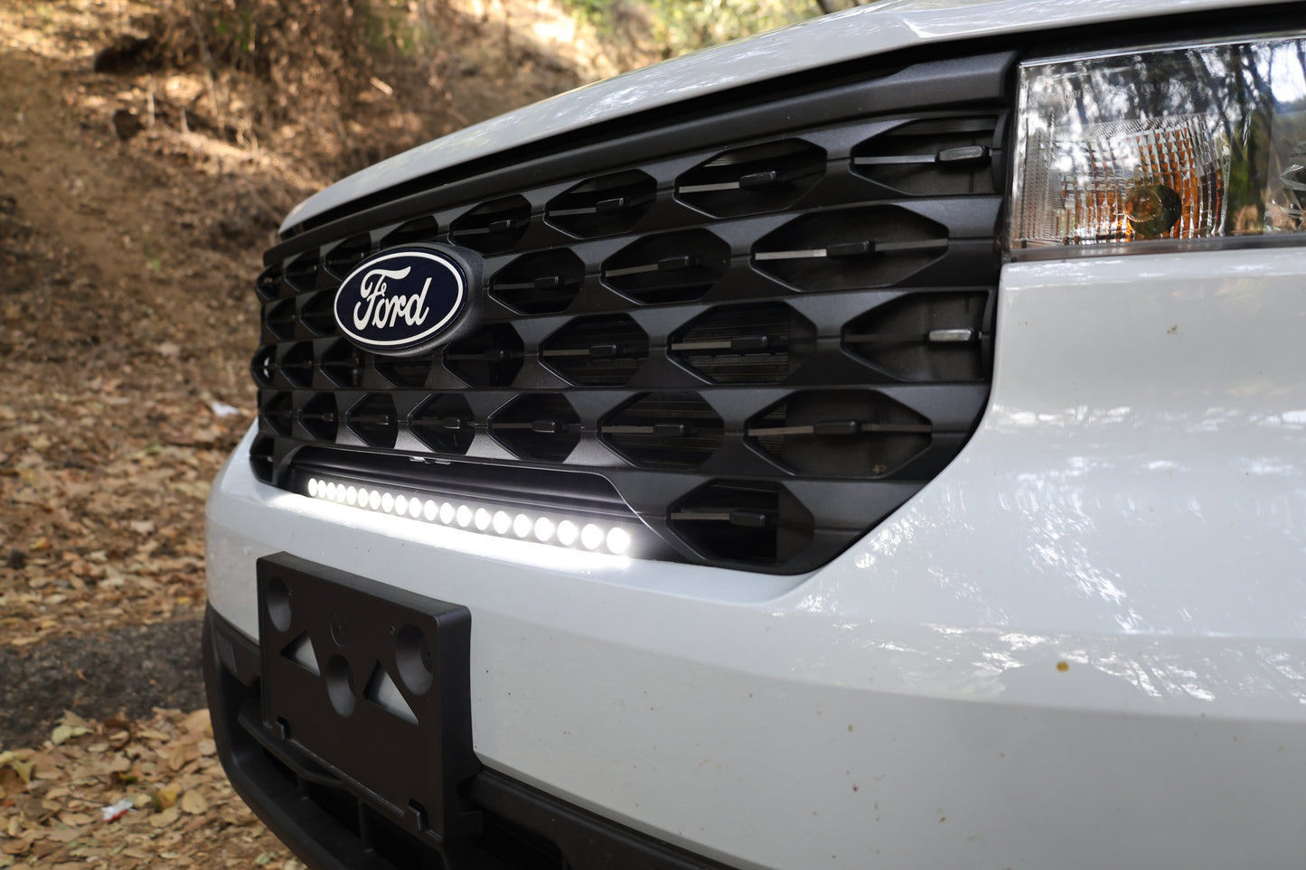 Close-up of a Ford vehicle's front grille with a light bar.