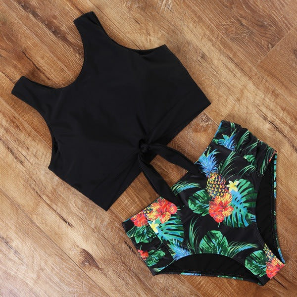 Black tank top and floral shorts on a wooden floor