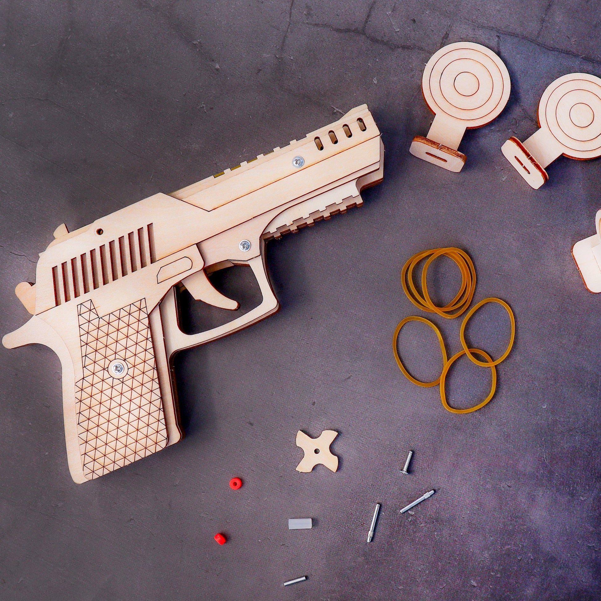 Wooden toy gun with accessories on a dark surface