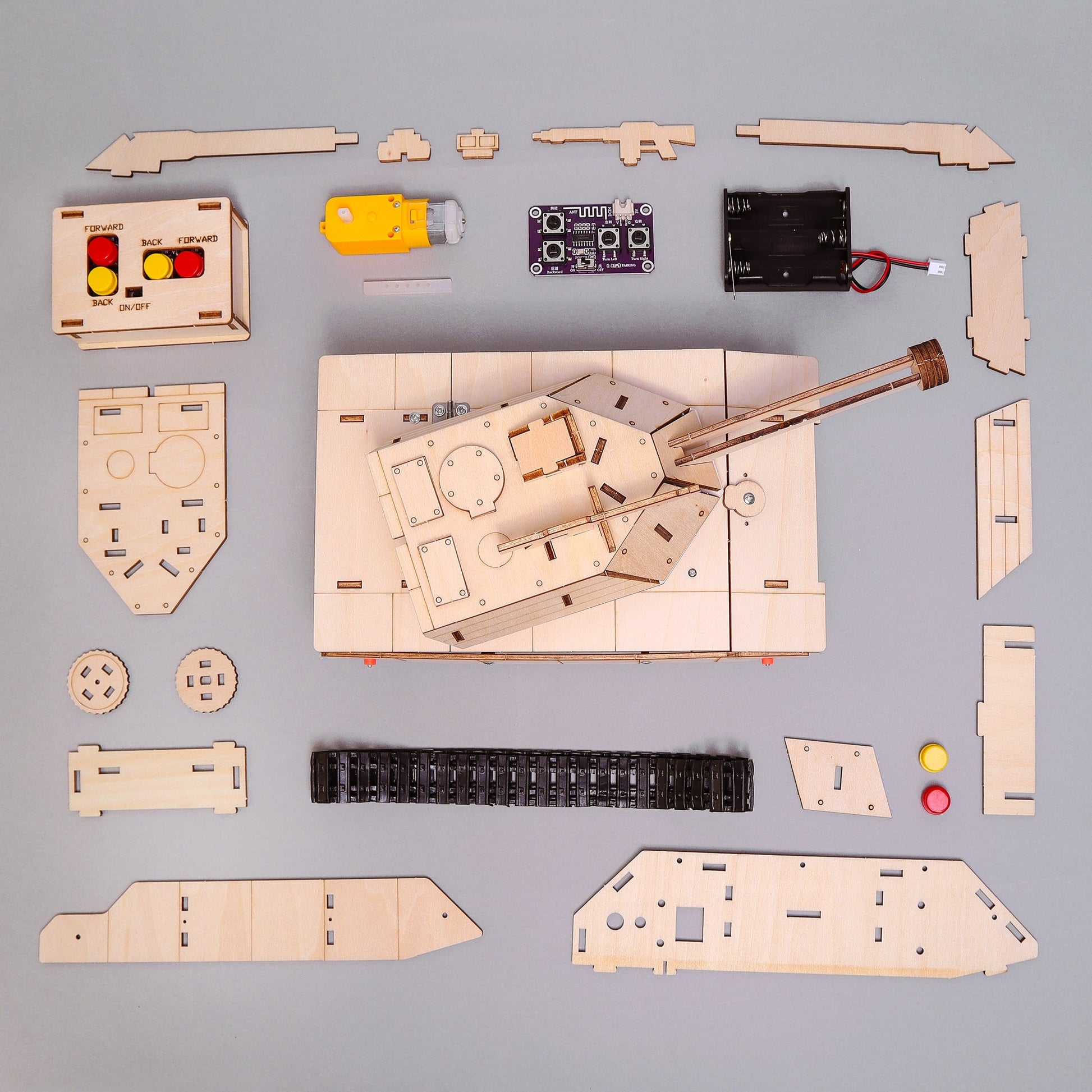 Wooden model kit of a tank with assembled and unassembled parts on a gray background