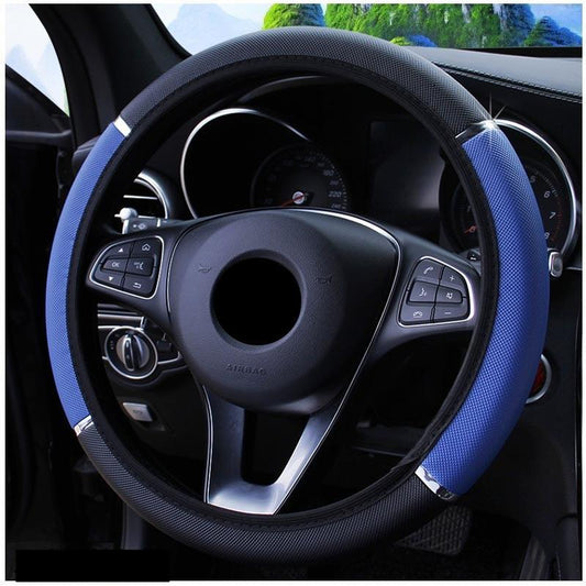Blue steering wheel cover on a car steering wheel with a blurred outdoor background