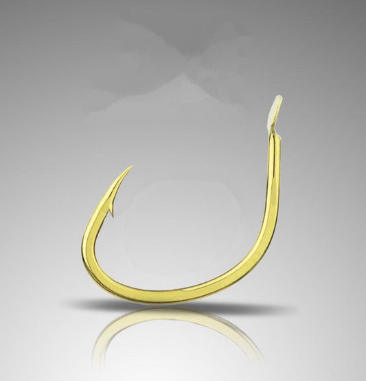 Gold fishing hook on a reflective gray surface