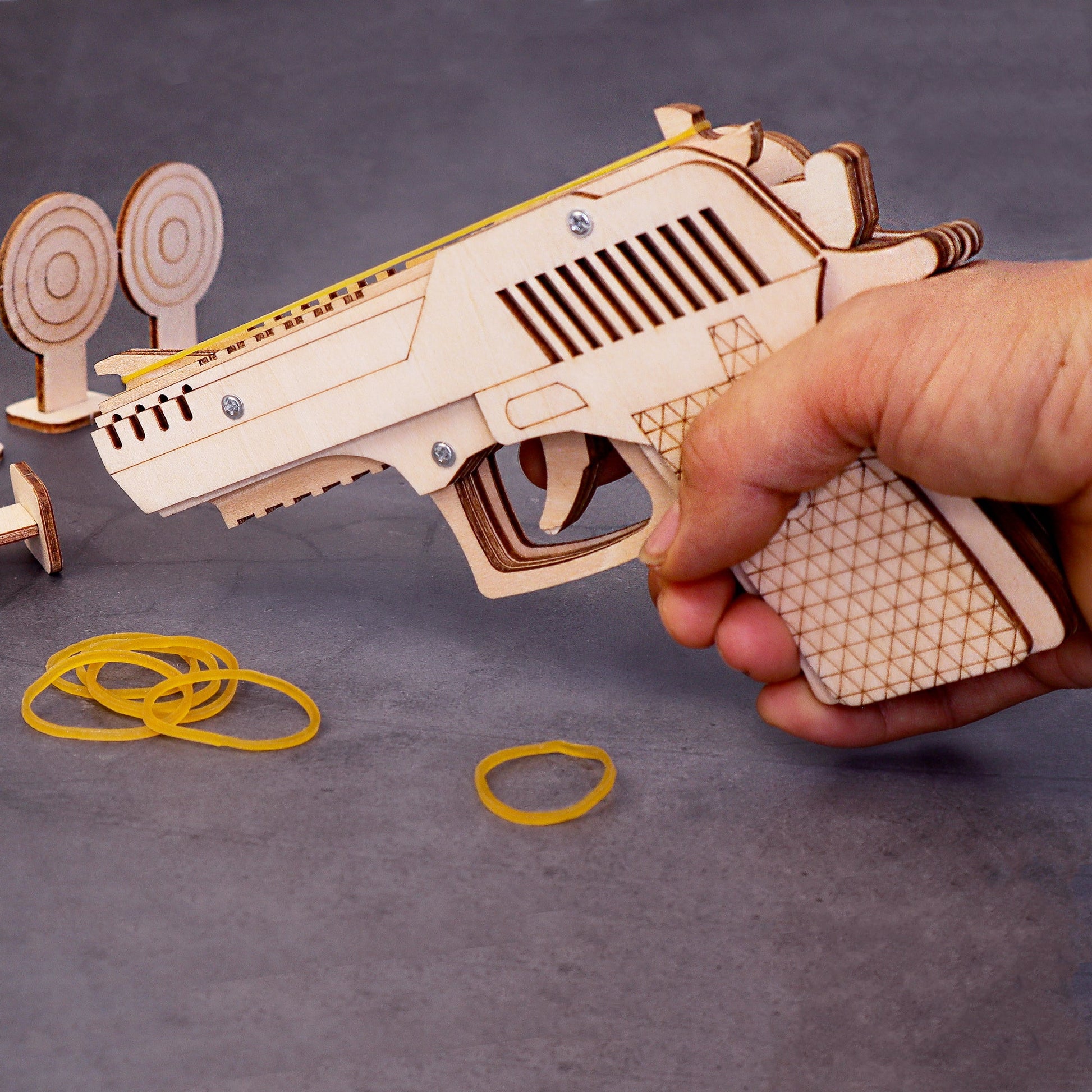 Wooden toy gun with rubber bands on a gray background