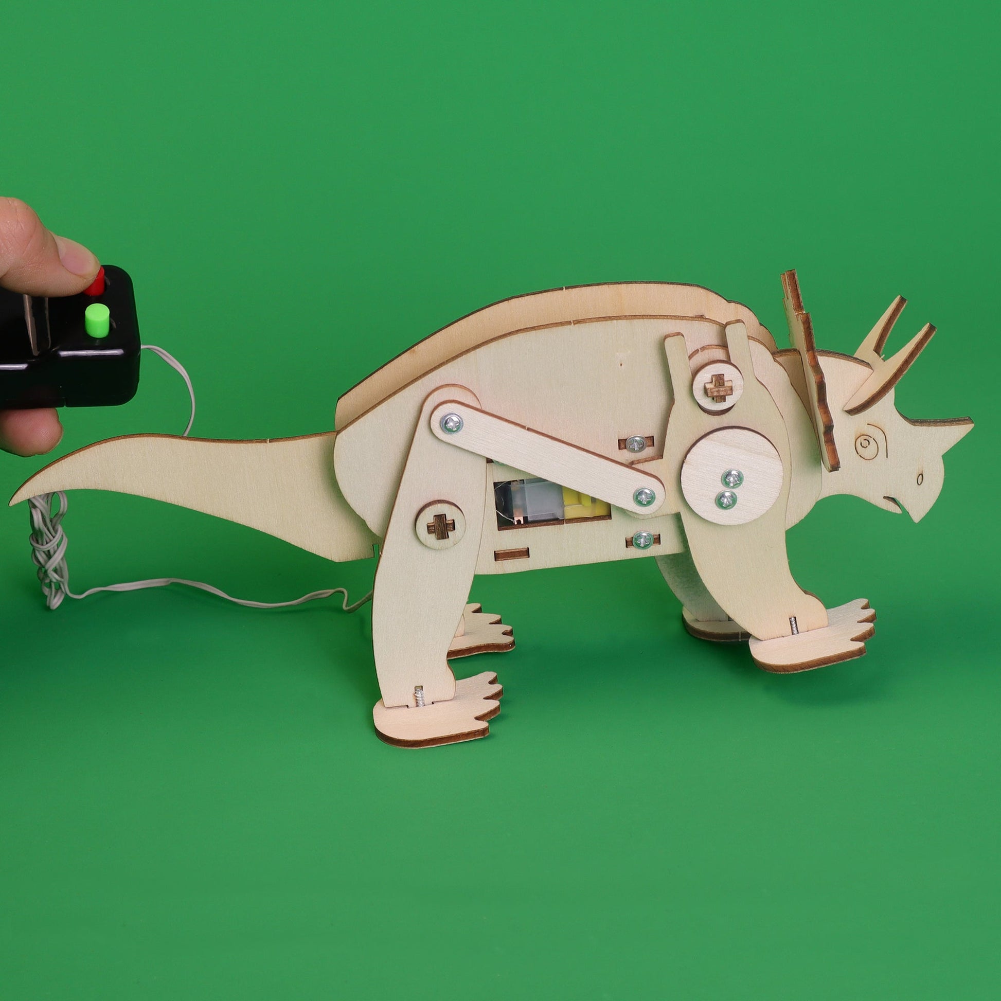 Wooden model of a triceratops with electronic components on a green background