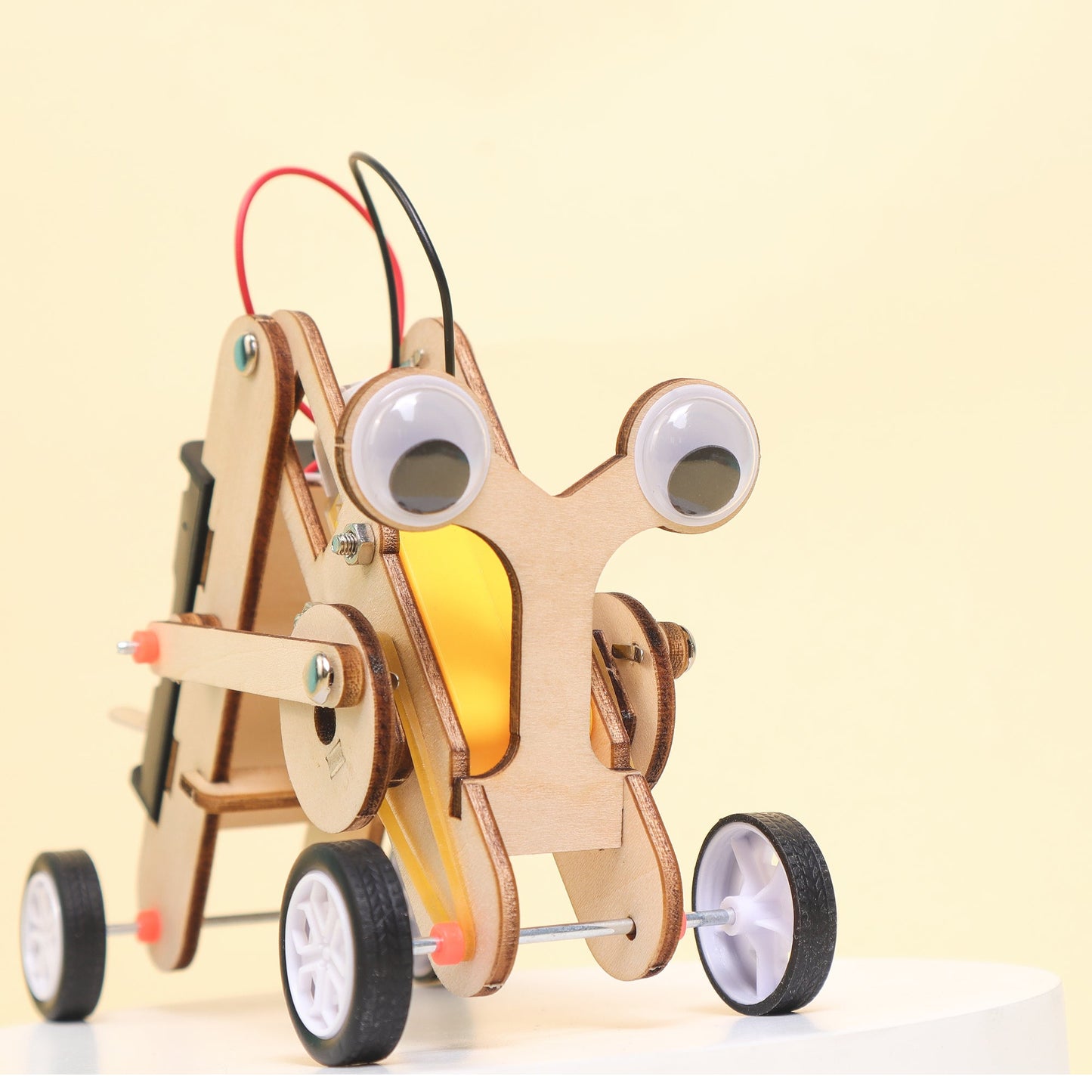 Wooden toy robot with wheels and a light bulb on a beige background