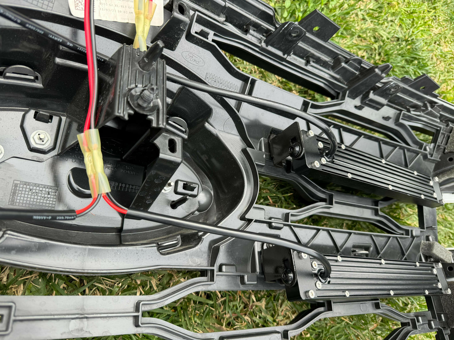 Close-up of LED Light Bars with wiring on a grassy background