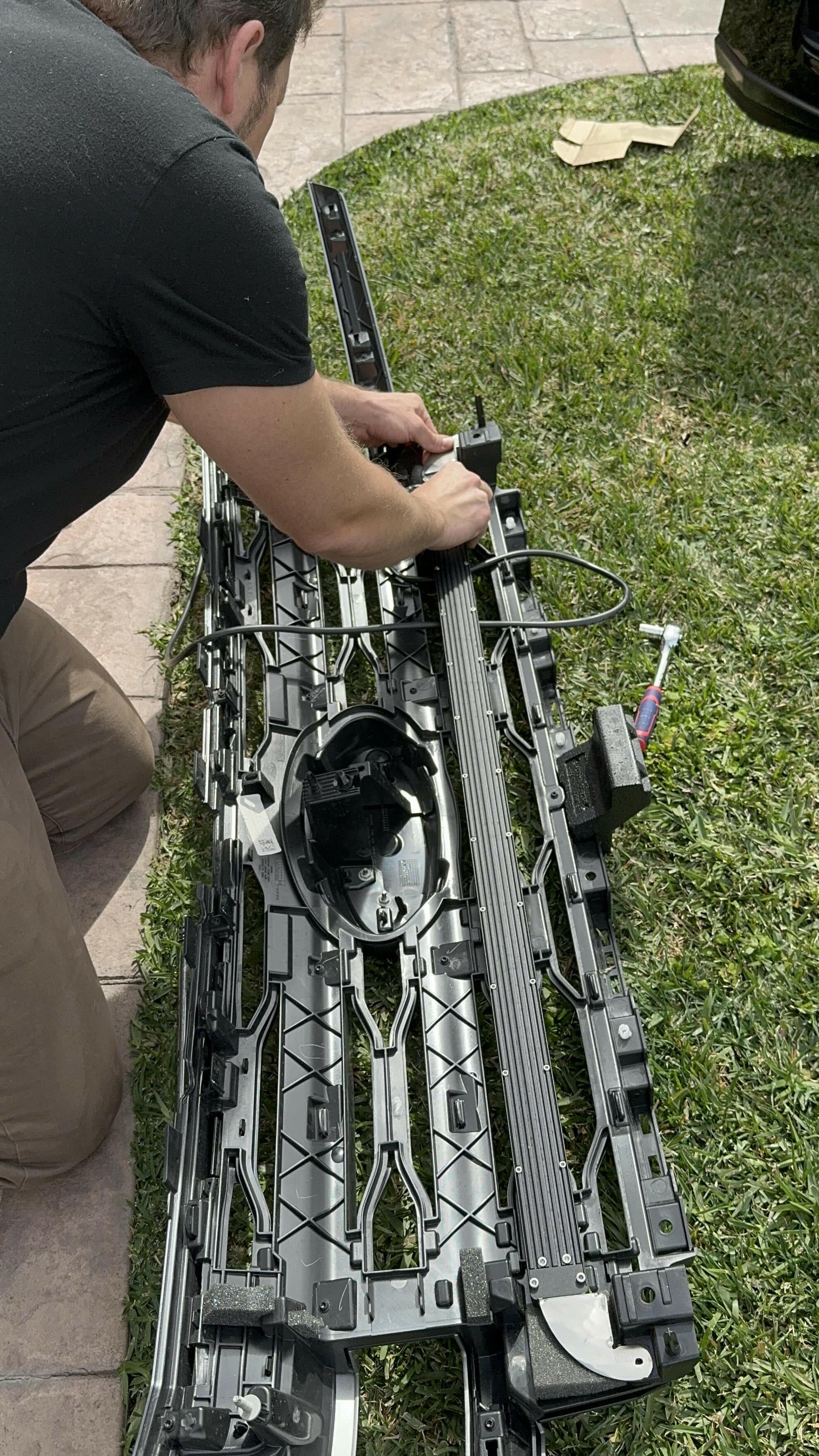 Person working on an LED Light Bar   outdoors on grass