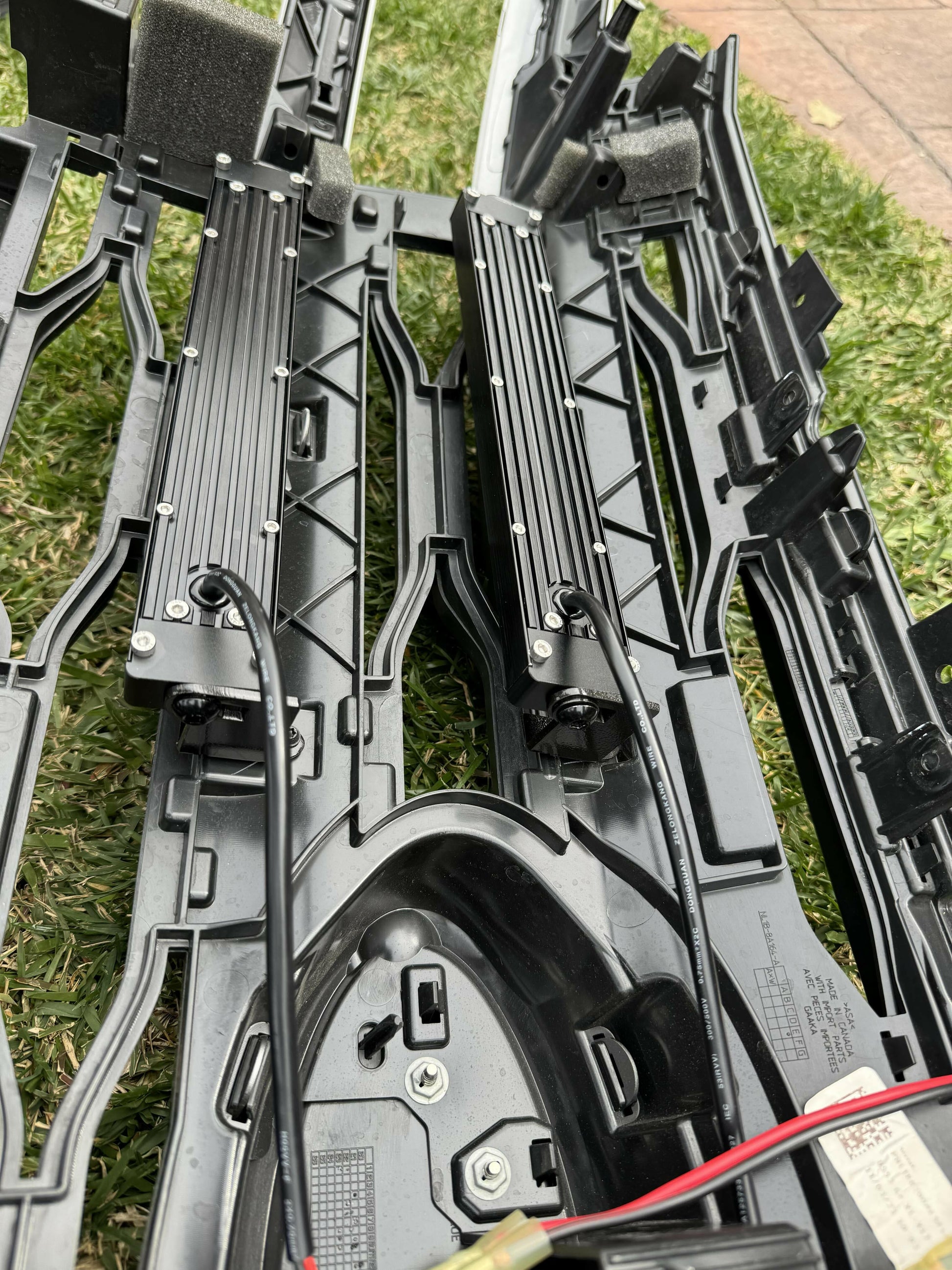 Close-up of LED Light Bars with visible electrical components on grass.