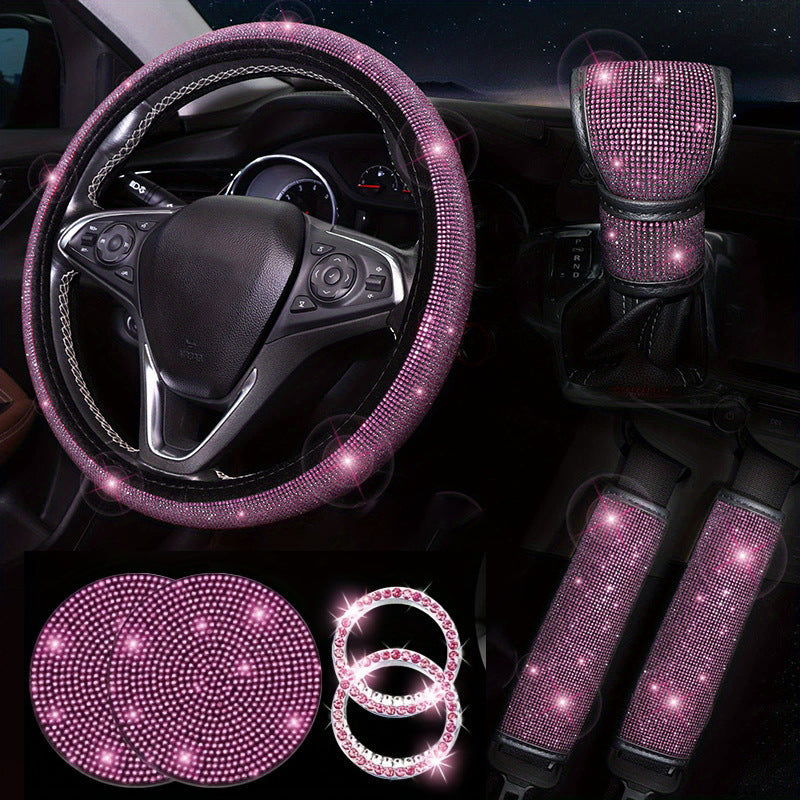 Pink car interior accessories set including steering wheel cover, gear shift cover, and coasters on a dark background.