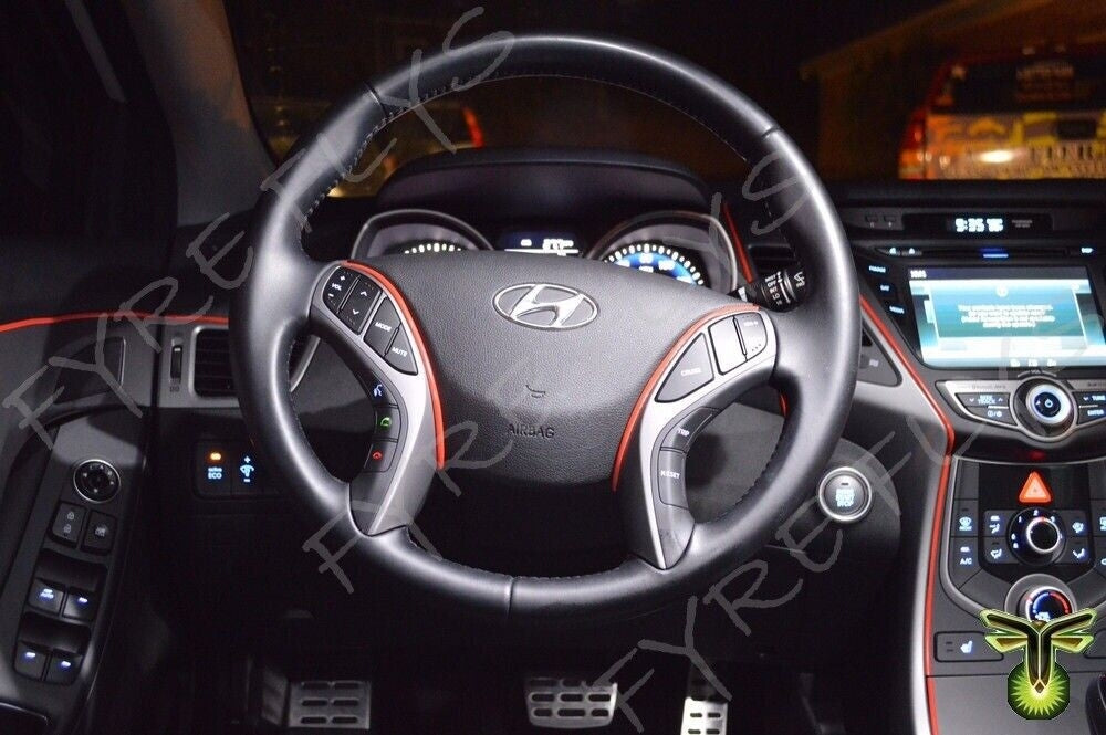 Steering wheel of a Hyundai vehicle with dashboard and infotainment system in the background.