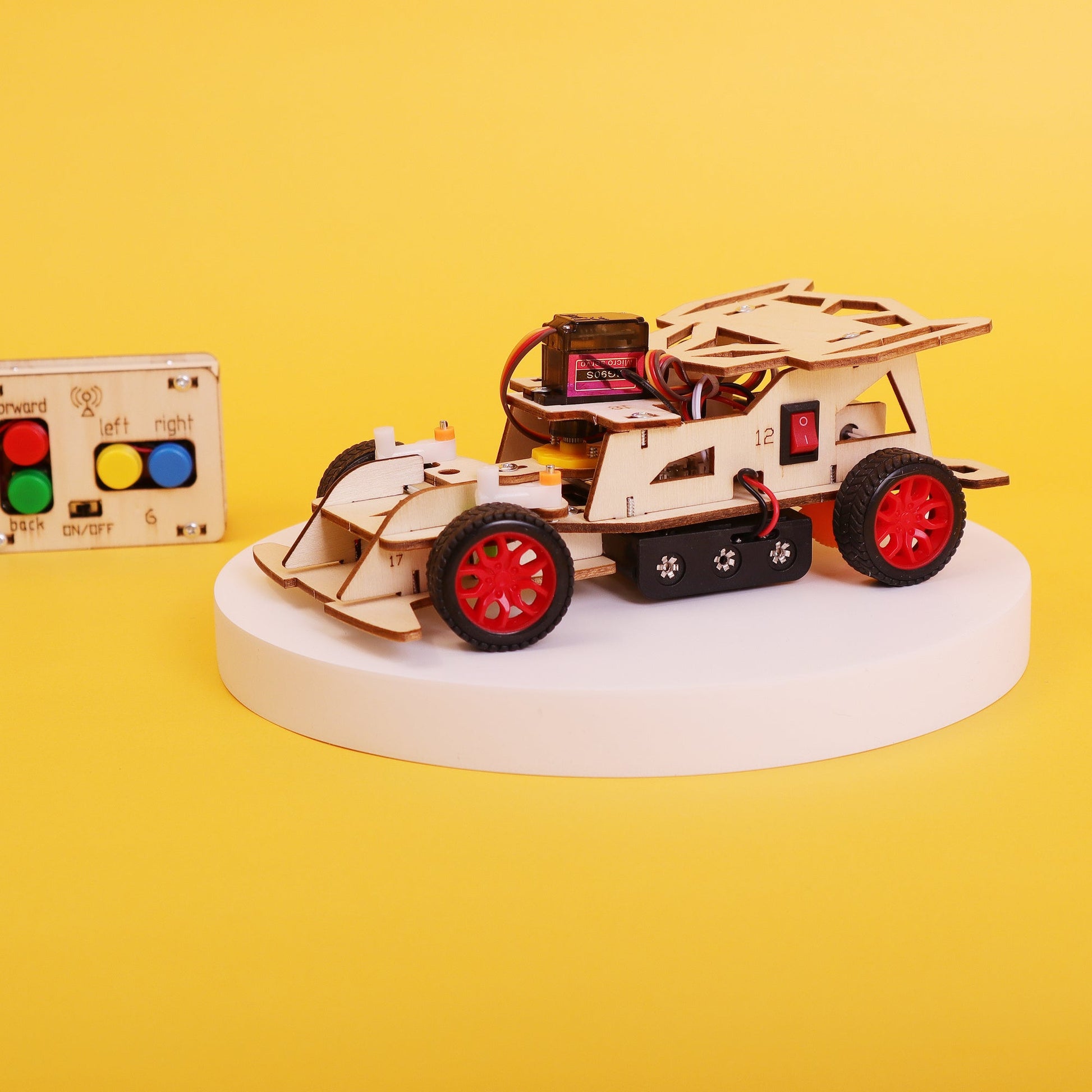 Wooden toy car model with red wheels on a yellow background