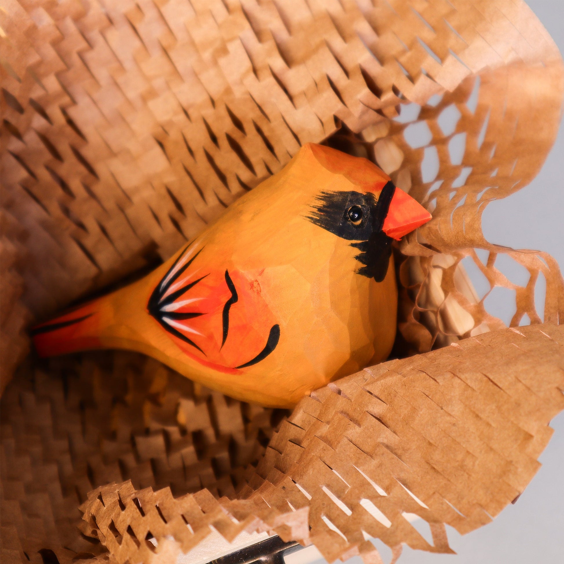 Wooden cardinal bird figure inside a woven basket