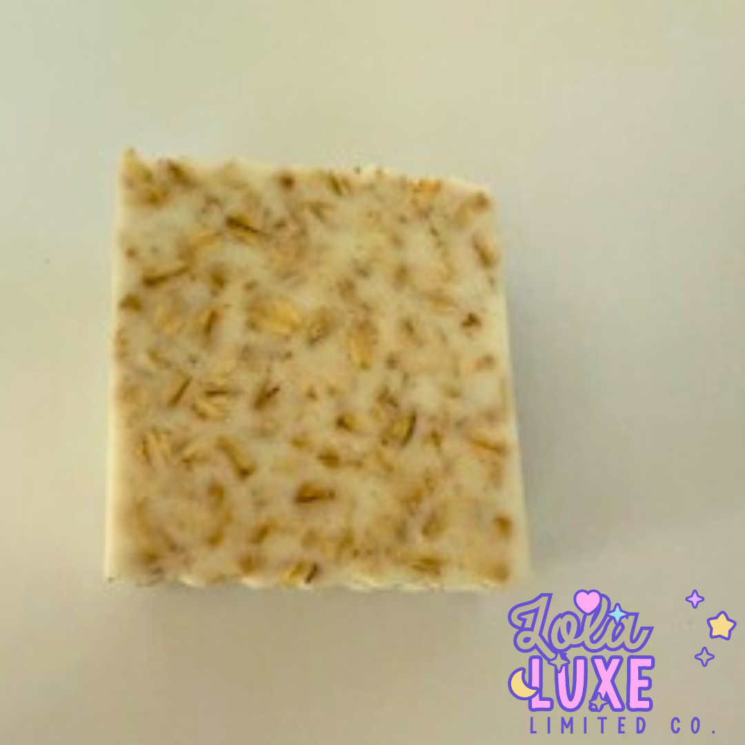 Square bar of soap with visible oatmeal pieces on a light background, featuring the brand 'Loli Luxe Limited Co.'