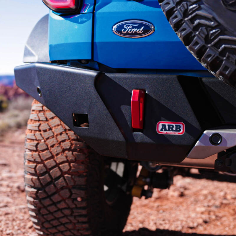 Close-up of a blue Ford vehicle with a black bumper and red ARB logo on a dirt road.