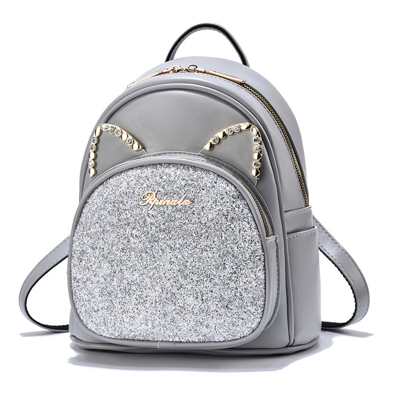Gray backpack with glittery front and cat ear details on a white background