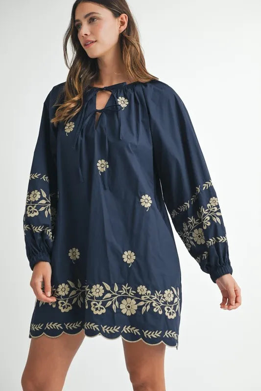 Navy blue dress with floral embroidery on a white background