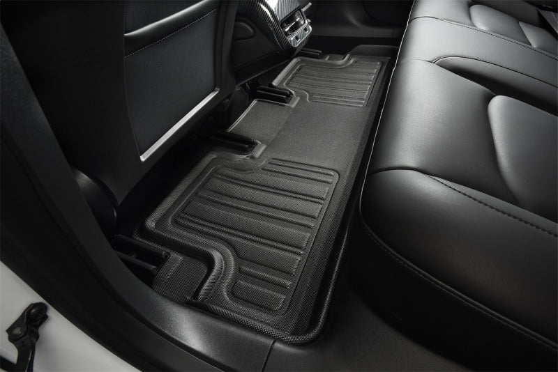 Car interior with black floor mats on a black leather seat