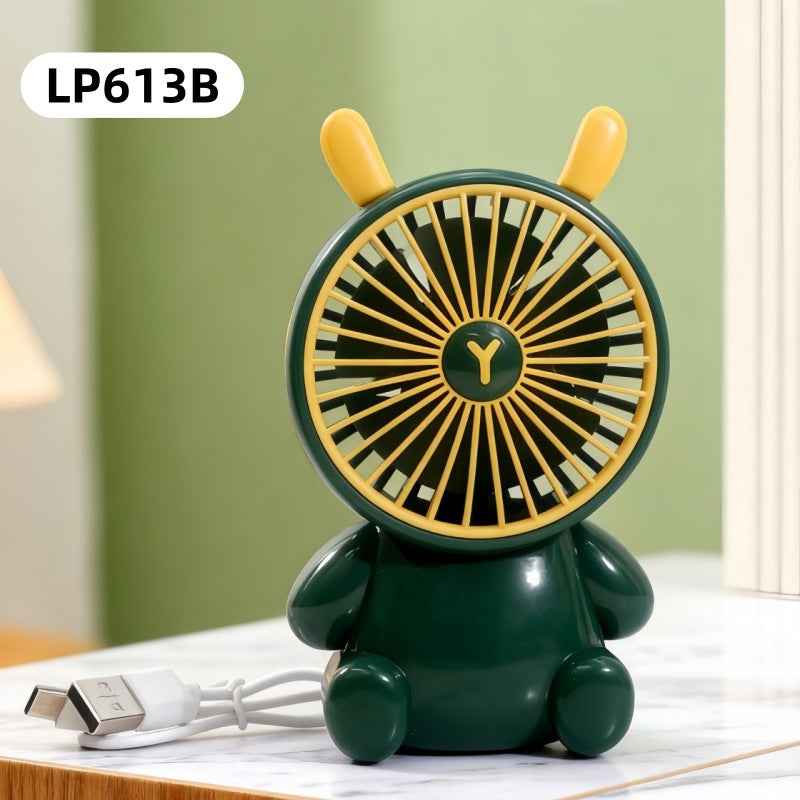 Green and yellow fan shaped like a bear on a table with a green wall background
