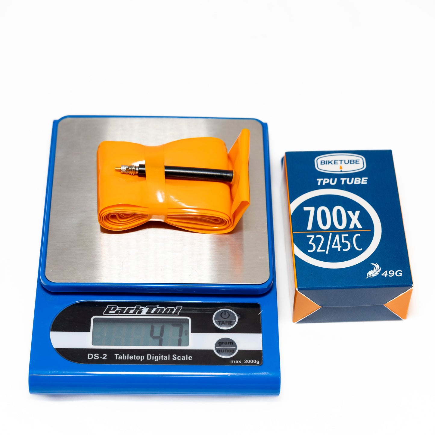 Orange bicycle tube on a digital scale with a box labeled 'Biketube' in the background.