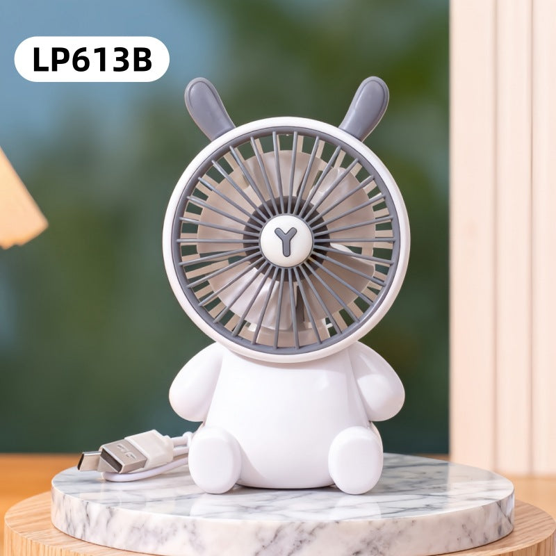 White rabbit-shaped fan on a marble base with a blurred green background