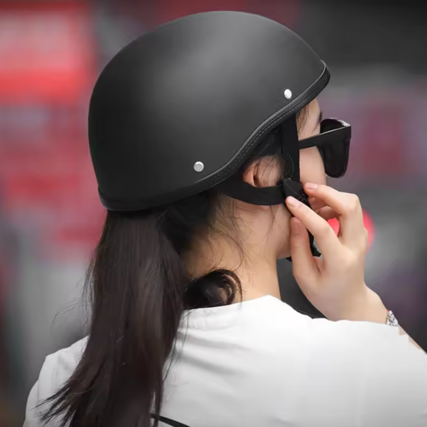 Person wearing a black helmet and sunglasses with a blurred background