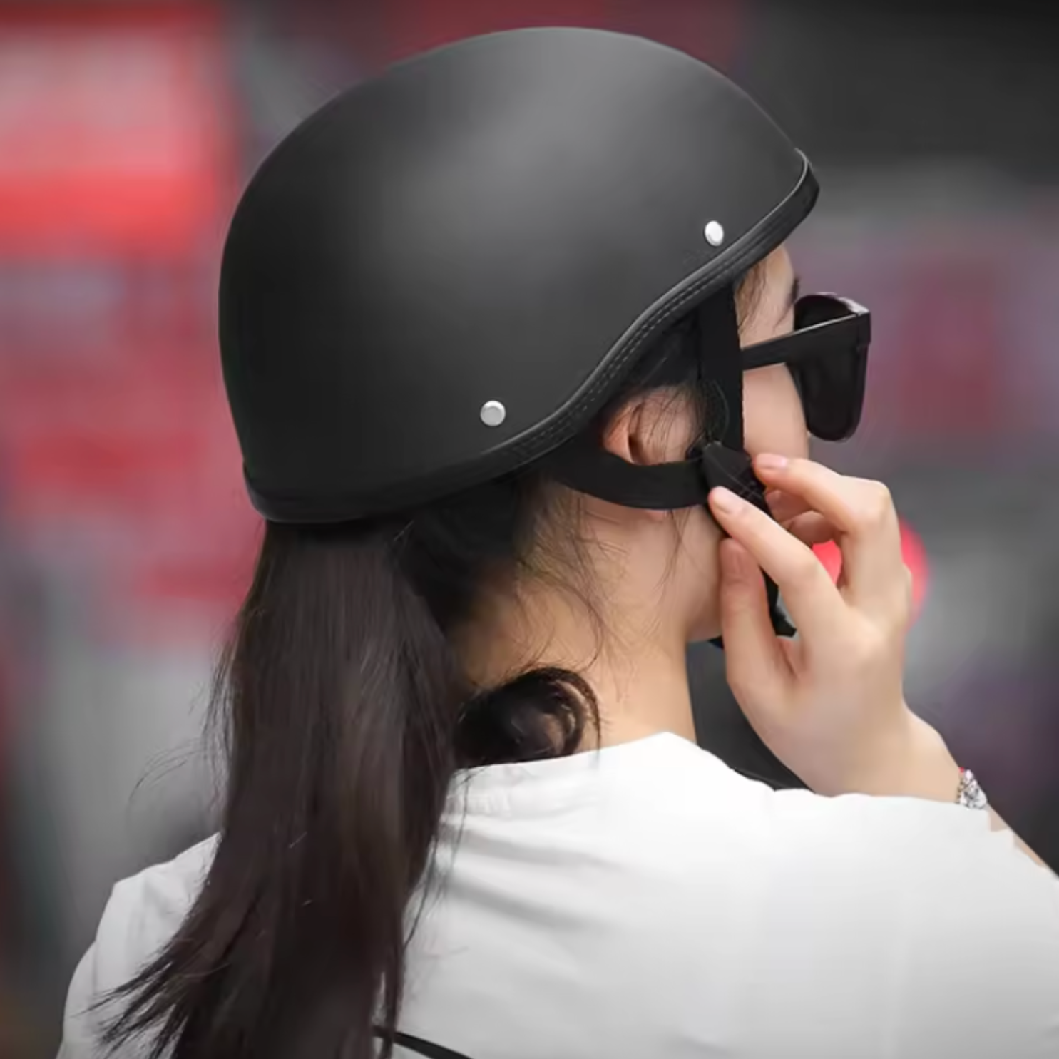 Person wearing a black helmet and sunglasses with a blurred background