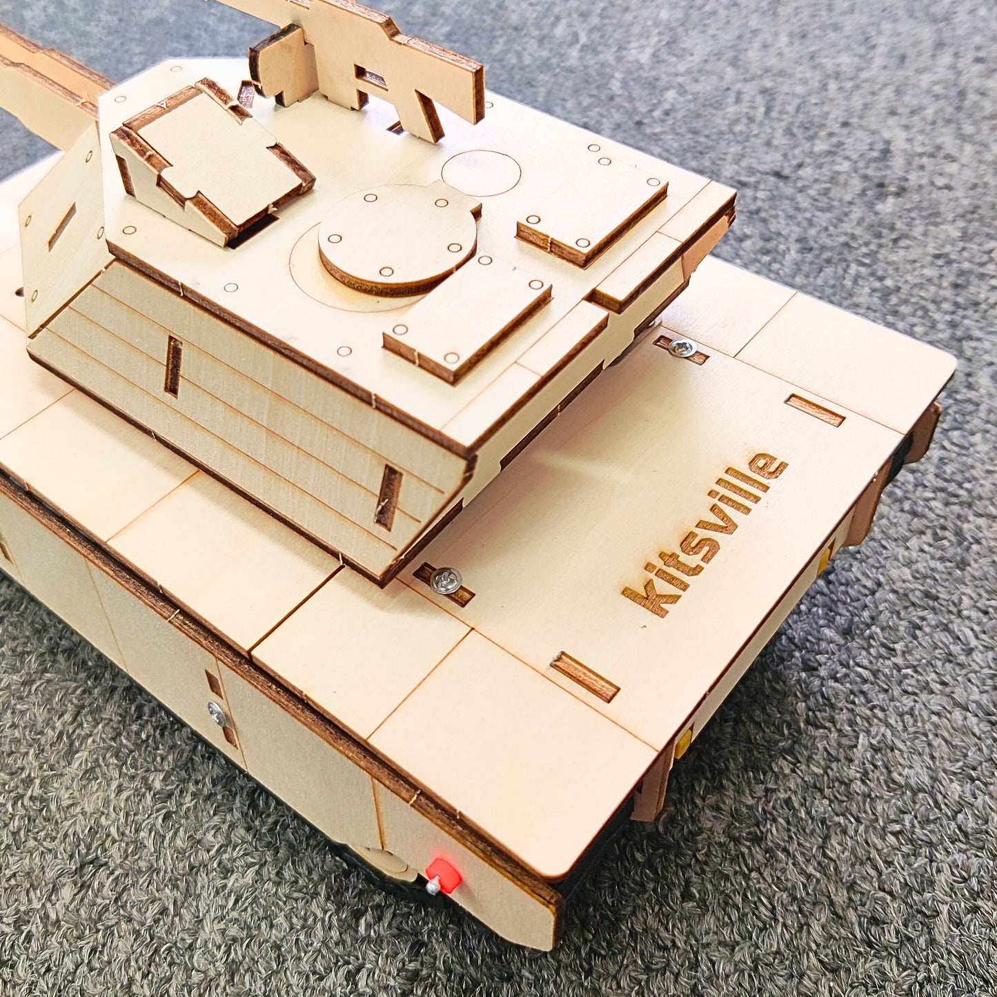 Wooden model kit with 'kitsville' branding on a gray surface