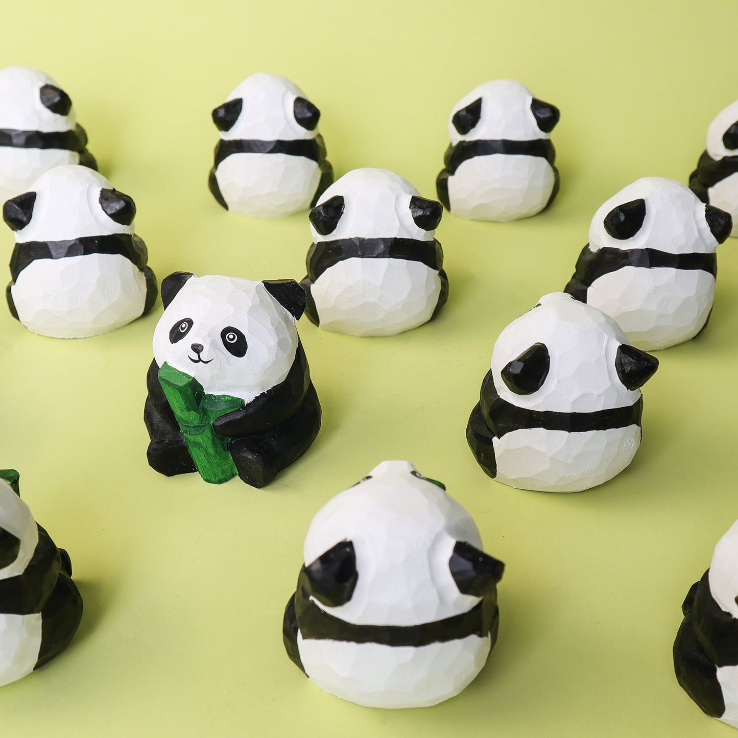 Panda-shaped figurines on a green background