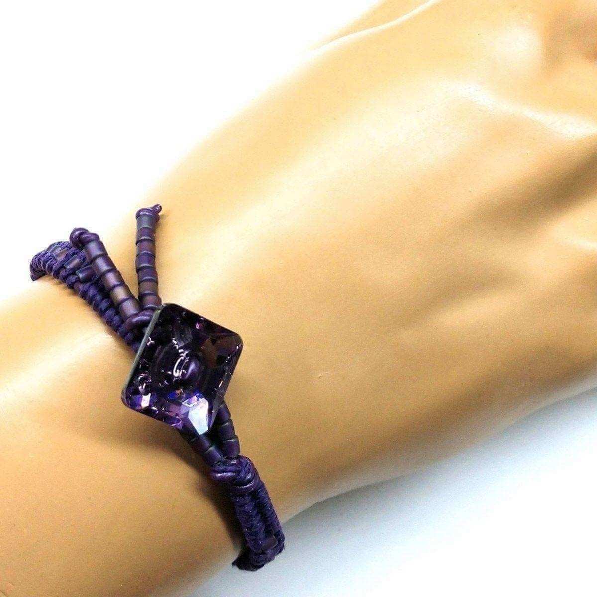 Purple bracelet with a large purple gemstone on a mannequin wrist.