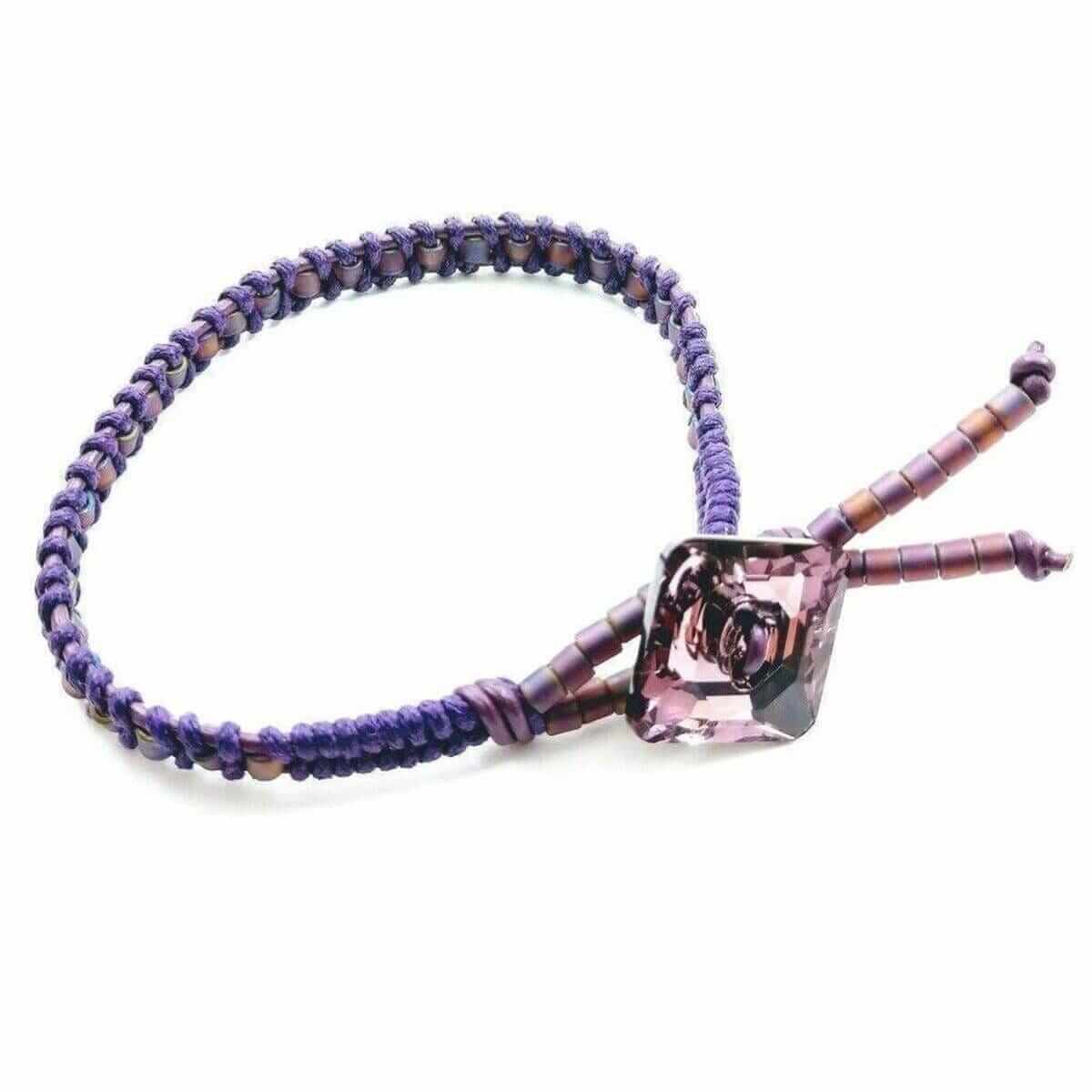 Purple beaded bracelet with a pink rose charm on a white background