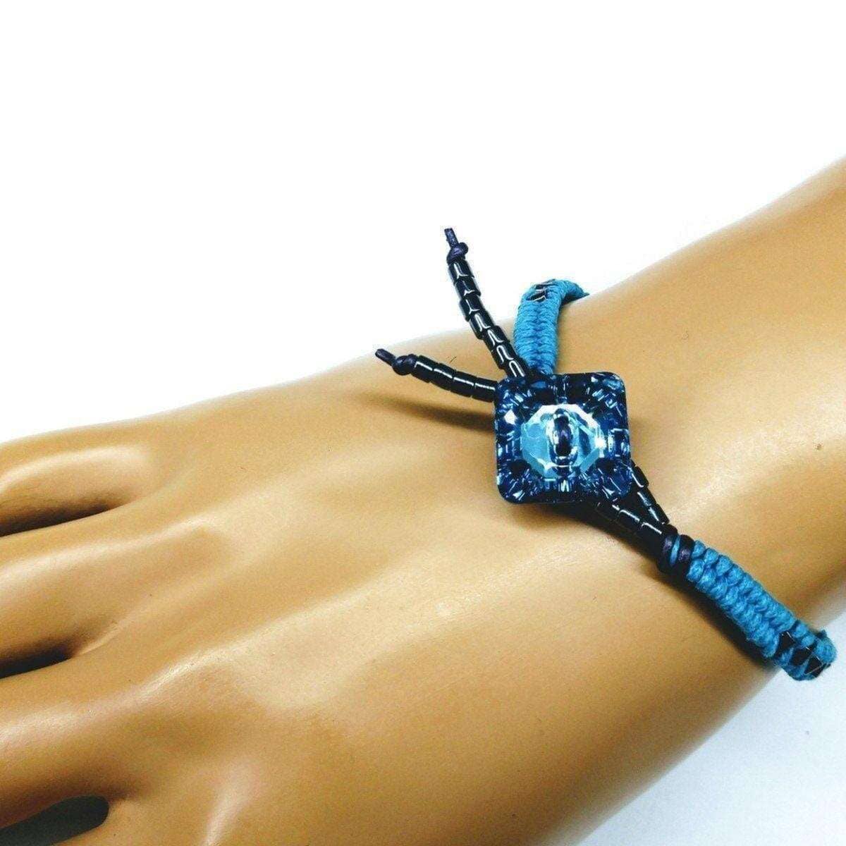 Blue and black braided bracelet on a mannequin wrist with a white background