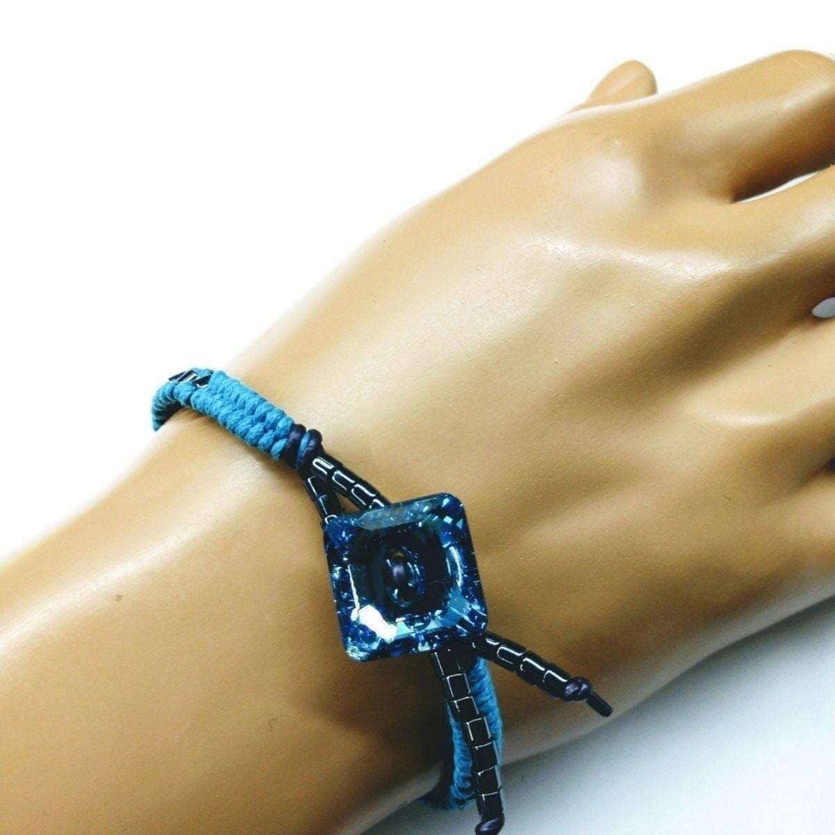 Blue and black bracelet on a mannequin wrist against a white background