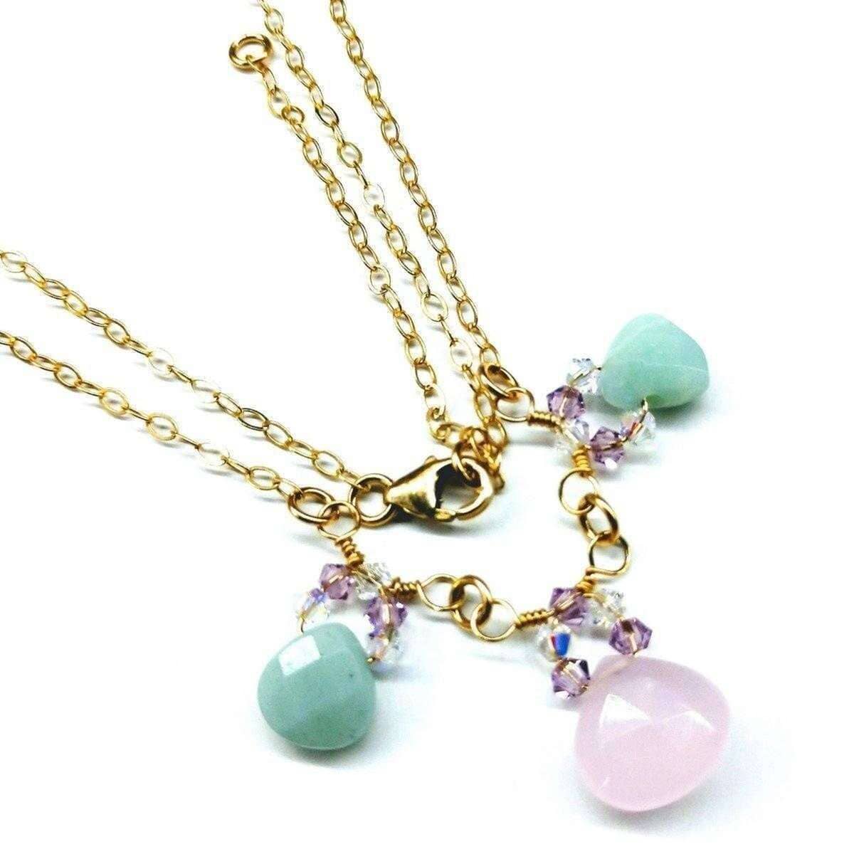 Gold necklace with turquoise and pink beads on a white background