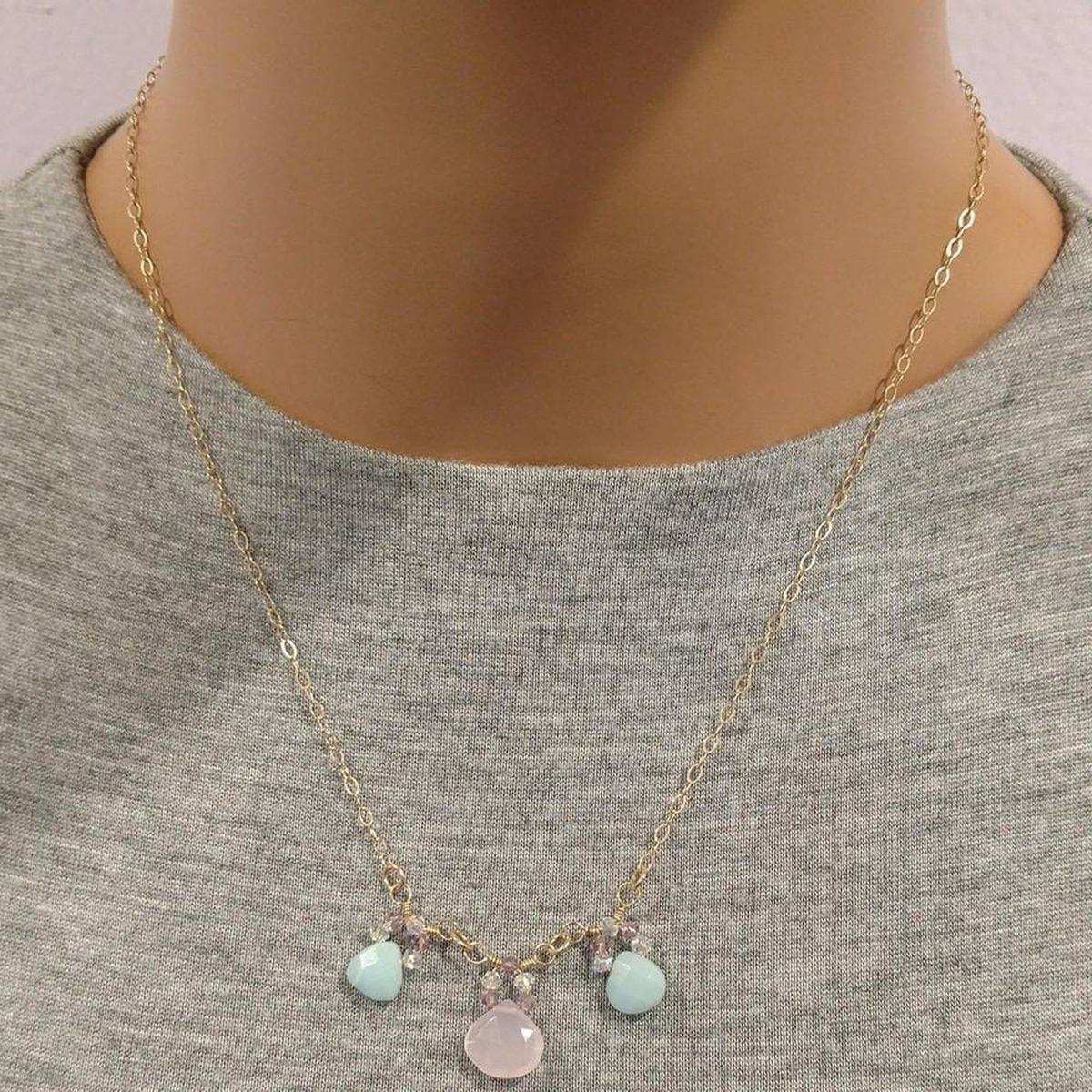 Necklace with colorful charms on a mannequin wearing a gray shirt