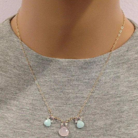 Necklace with colorful charms on a mannequin wearing a gray shirt