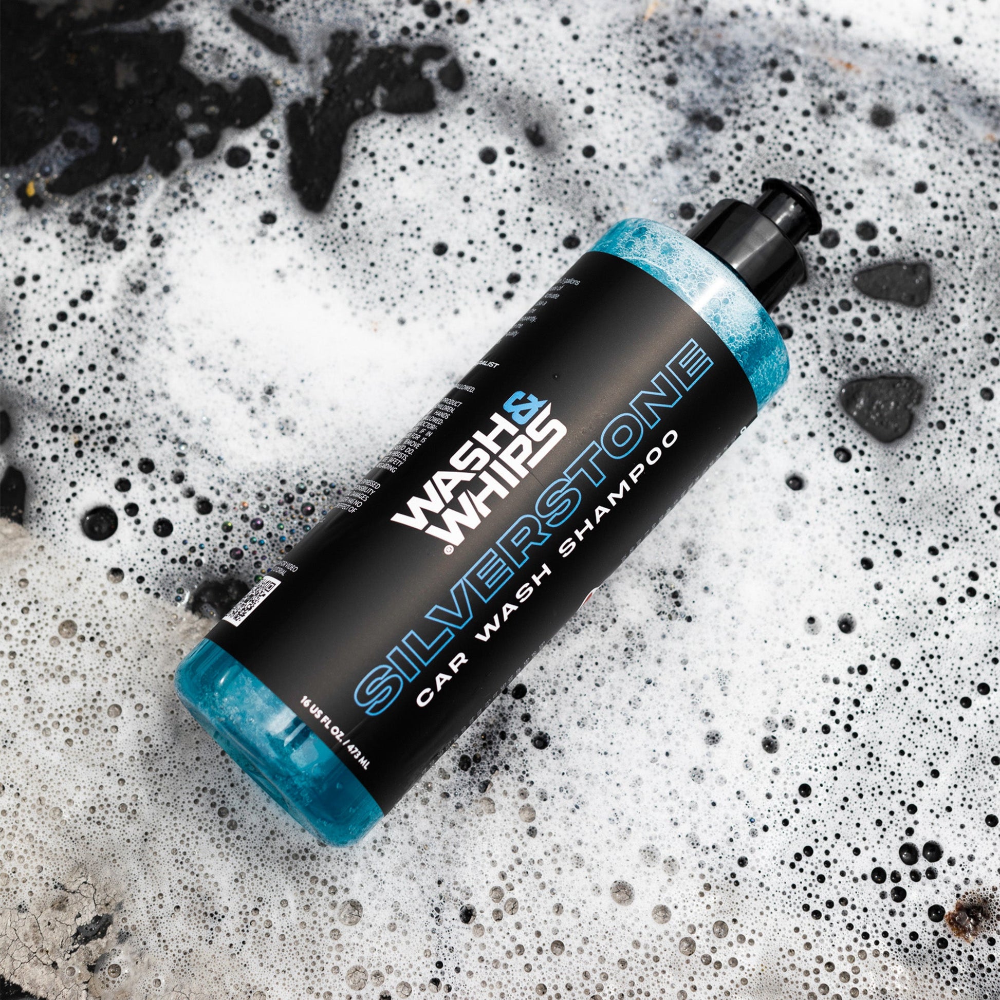 Bottle of Silverstone car wash shampoo on a soapy surface
