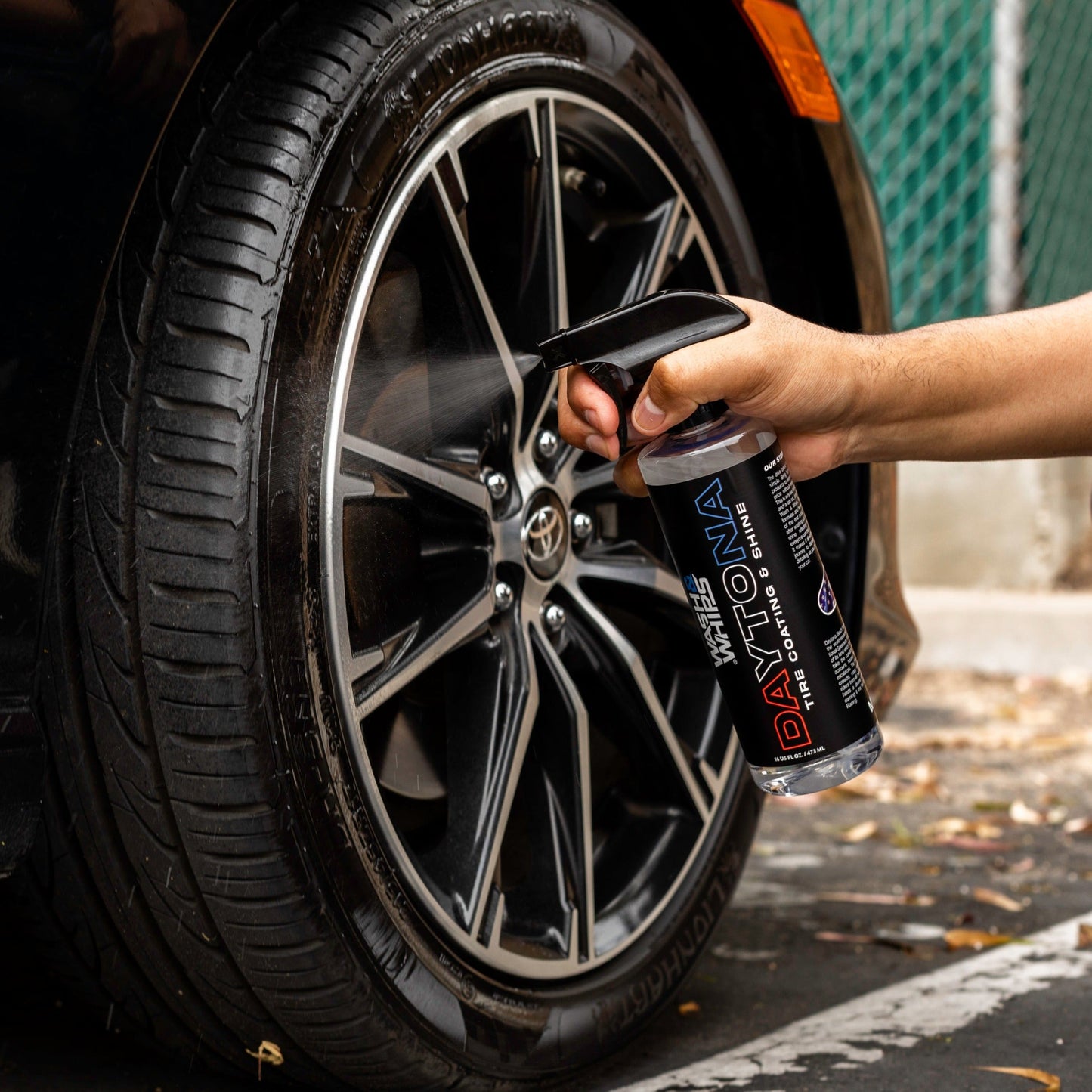 Person applying a tire coating product to a car tire