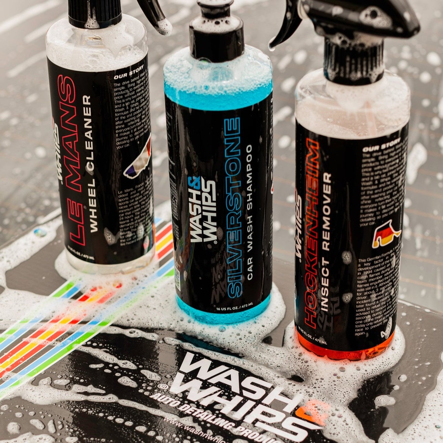 Three bottles of car care products on a soapy surface with visible branding.