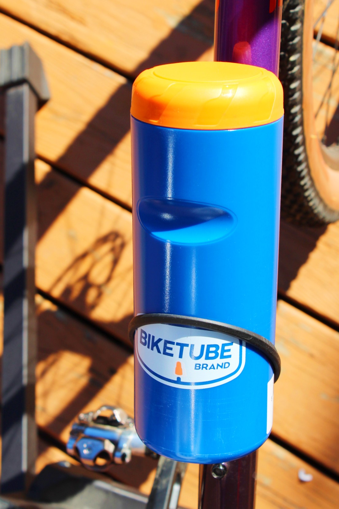 Blue bike tube with yellow cap on a wooden surface