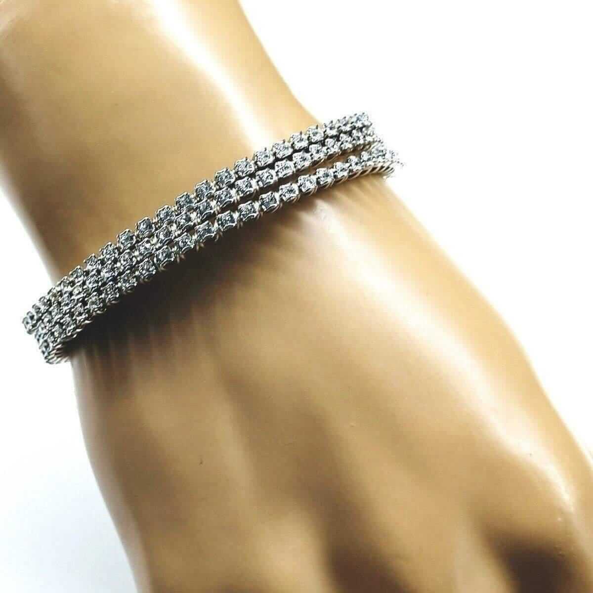 Silver bracelet with clear stones on a mannequin wrist against a white background
