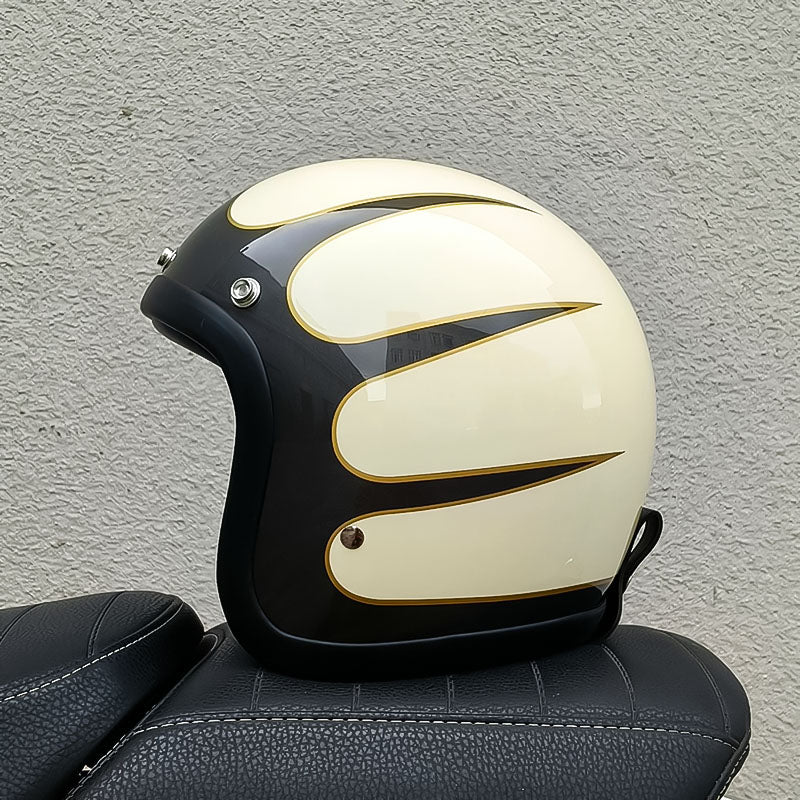 Black and white motorcycle helmet with gold accents on a textured gray background