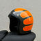 Orange and black motorcycle helmet on a textured gray background